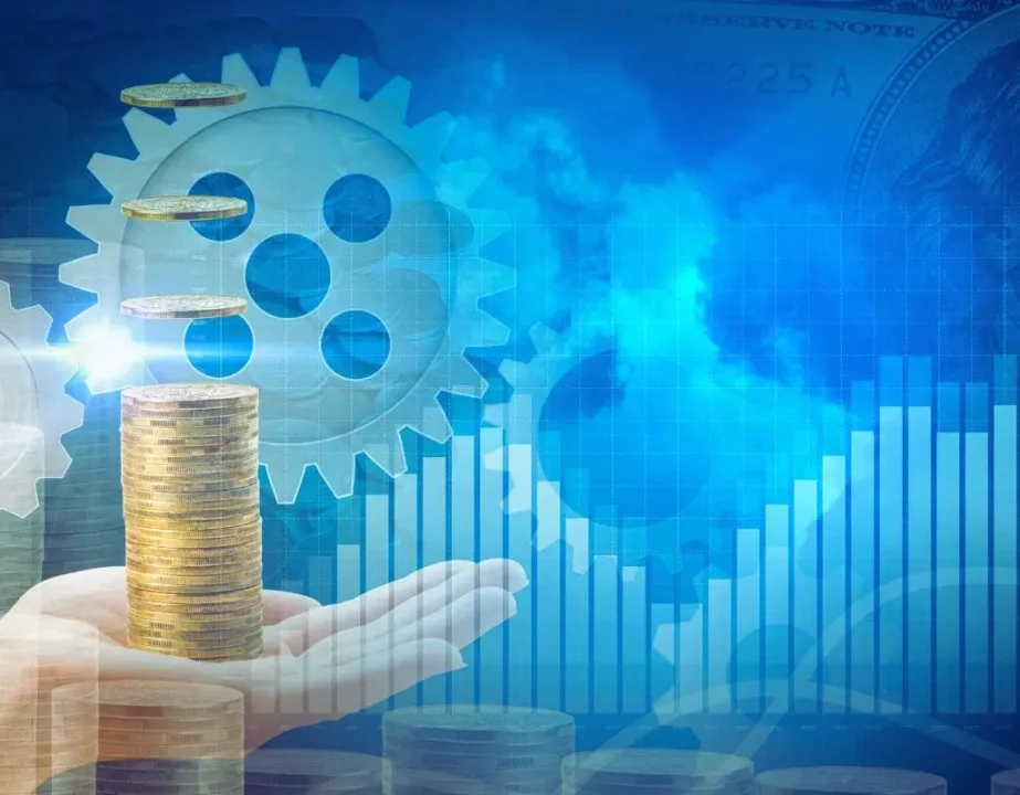 Dlaczego warto patrzeć szerzej, gdy myślisz o zatrudnianiu niepełnosprawnych i korzyściach z tym związanych? 4 Na ilustracji widać dłoń unoszącą stos monet, nad którymi unoszą się kolejne krążki – symbolizujące wzrost i inwestycję. W tle znajdują się zębatki i wykres słupkowy skierowany ku górze, co przywodzi na myśl rozwój, efektywność i dobrze funkcjonujący mechanizm. Całość utrzymana jest w niebiesko-złotej kolorystyce, co buduje atmosferę zaufania, stabilności i sukcesu finansowego. Ten obraz może symbolizować pytanie: jakie są korzyści z zatrudnienia osoby niepełnosprawnej – pokazując, że włączenie takich osób do zespołu to nie tylko gest społeczny, ale też realna wartość dla firmy. Dłoń reprezentuje wsparcie, monety – zysk, a tryby – efektywną współpracę. Całość przekazuje poczucie synergii, rozwoju i sensownej inwestycji.