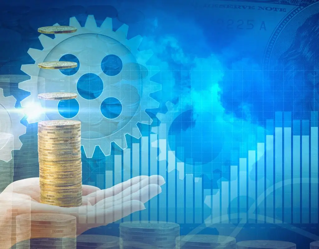 Na ilustracji widać dłoń unoszącą stos monet, nad którymi unoszą się kolejne krążki – symbolizujące wzrost i inwestycję. W tle znajdują się zębatki i wykres słupkowy skierowany ku górze, co przywodzi na myśl rozwój, efektywność i dobrze funkcjonujący mechanizm. Całość utrzymana jest w niebiesko-złotej kolorystyce, co buduje atmosferę zaufania, stabilności i sukcesu finansowego. Ten obraz może symbolizować pytanie: jakie są korzyści z zatrudnienia osoby niepełnosprawnej – pokazując, że włączenie takich osób do zespołu to nie tylko gest społeczny, ale też realna wartość dla firmy. Dłoń reprezentuje wsparcie, monety – zysk, a tryby – efektywną współpracę. Całość przekazuje poczucie synergii, rozwoju i sensownej inwestycji.