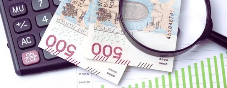 Obrazek do artykułu - dofinansowanie na pracownika niepełnosprawnego. Na obrazku znajduje się kilka elementów związanych z finansami. Widzimy dwa banknoty o nominale 500 złotych polskich, umieszczone obok kalkulatora i lupy. Kalkulator ma duże przyciski, widoczny jest między innymi przycisk do obliczeń ("+/−"), a także czerwony przycisk z napisem "ON C.CE". Lupa jest umieszczona na banknotach, co symbolizuje bliższe przyjrzenie się finansom, analizę lub kontrolę kosztów. W tle widoczny jest fragment wykresu ze słupkami w kolorze zielonym, który może symbolizować wzrost finansowy lub statystyki. Cała scena sugeruje tematykę związaną z analizą finansową, budżetowaniem lub planowaniem wydatków.