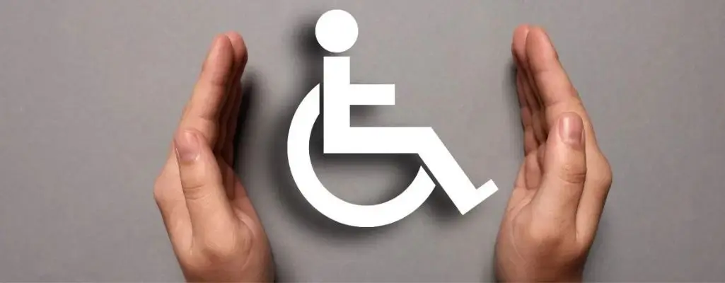 Zdjęcie w artykule Dofinansowanie do wynagrodzeń PFRON. Ukazany 2 dłonie w geście ochraniającym. Między dłońmi symbol osoby na wózku inwalidzkim. Obrazek sugeruje opiekę i wsparcie dla osób niepełnosprawnych.