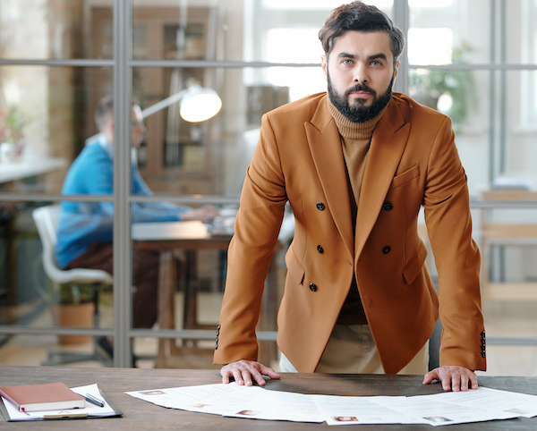 Portrait of bearded recruiter at table with resumes jak robimy rekrutację osób niepełnosprawnych