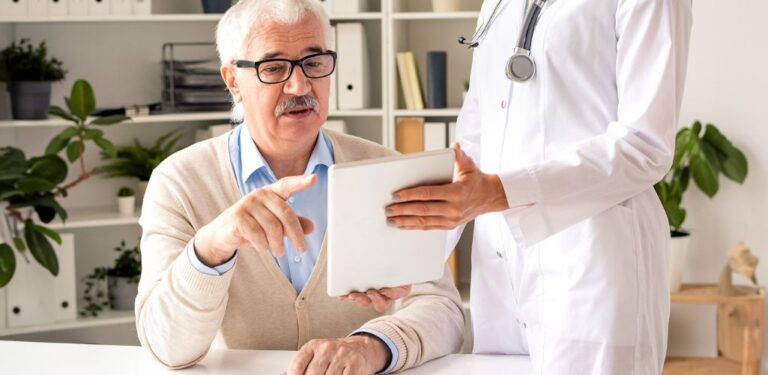 Obrazek wyróżniający do artykułu - na jakie choroby można dostać orzeczenie o niepełnosprawności. Widoczny lekarz pokazujący pacjentowi jakiś dokument.