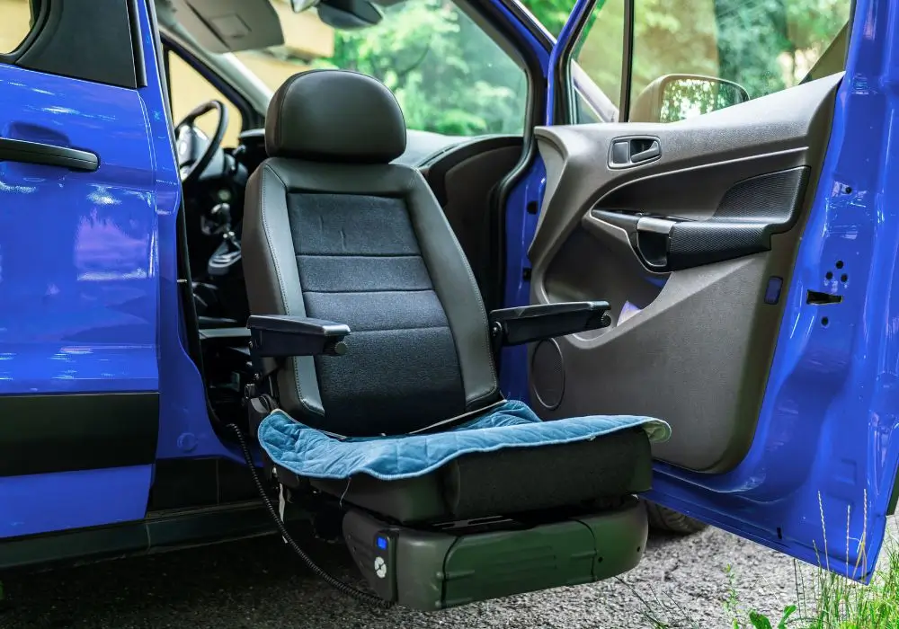 Samochód do przewozu osób niepełnosprawnych z zamontowanym obrotowym fotelem ułatwiającym wsiadanie i wysiadanie z pojazdu.