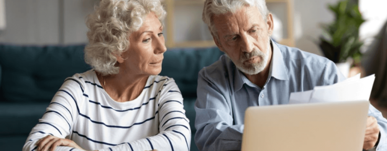 praca na rencie - starsi mężczyzna i kobieta przed laptopem pracują z dokumentami