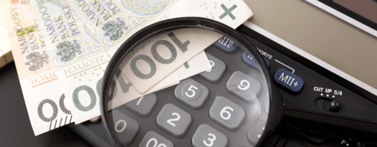 kalkulator,lupa i banknoty obrazujące pytania o wynagrodzenie minimalne