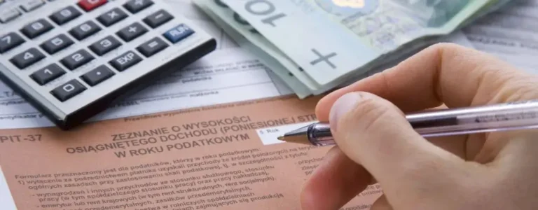 Obrazek wyróżniający do artykułu - ulga na dziecko w PIT. Widoczne długopisem nad zeznaniem podatkowym. Powyżej kalkulator i stos banknotów. Obrazek sugeruje rozliczenie pit.