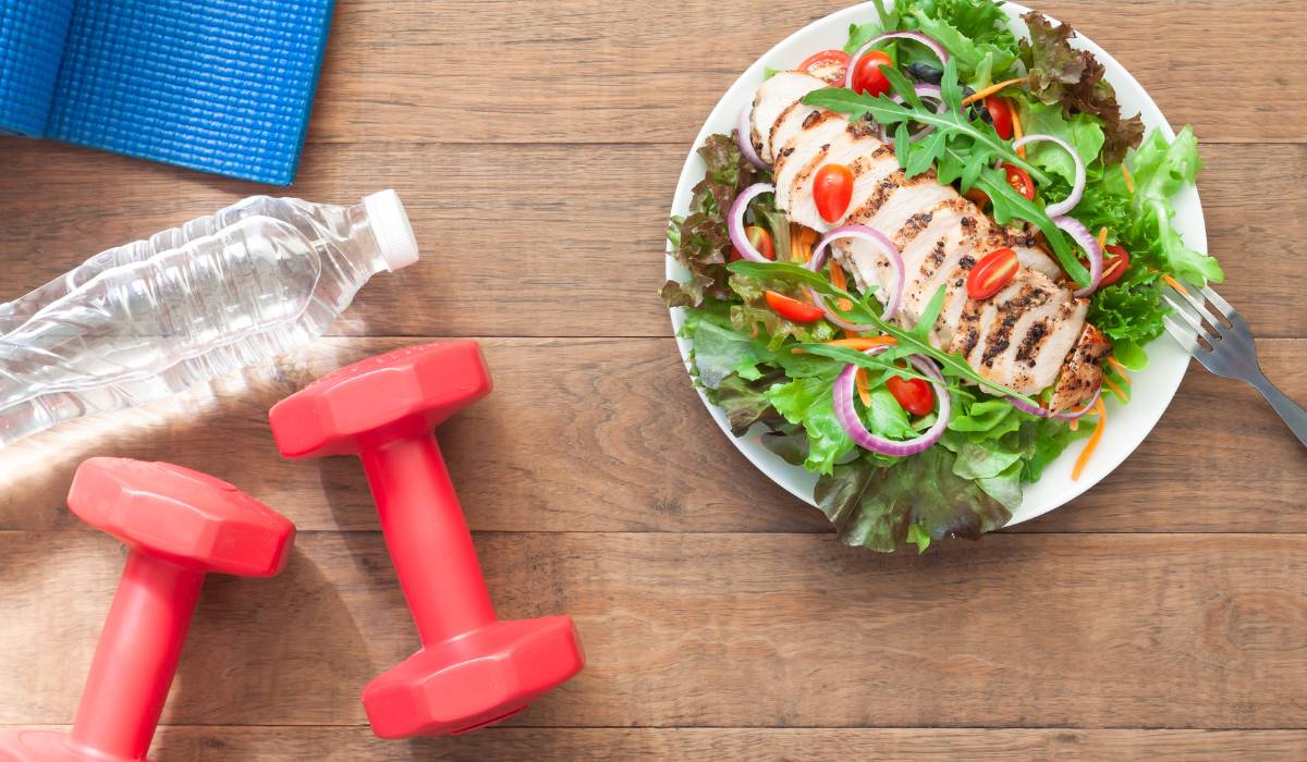 9 kluczowych nawyków dla lepszego zdrowia. Jak zapobiegać chorobom przez zmianę stylu życia? 1 Zdjęcie w artykule "9 nawyków dla lepszego zdrowia" Na obrazku zdrowe jedzenie, woda, ciężarki do ćwiczeń