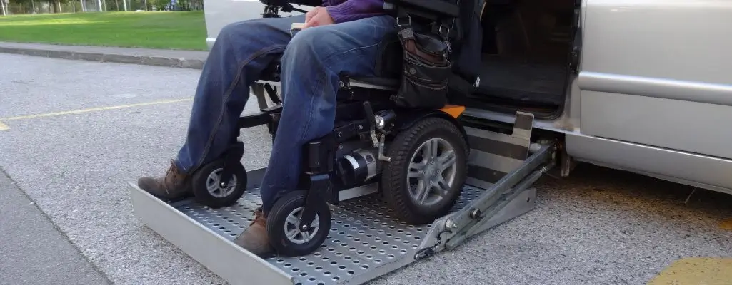Zdjęcie w artykule - rusza kolejny etap dofinansowania do samochodu. Na zdjęciu osoba na wózku inwalidzkim wciągana jest do samochodu osobowego windą.