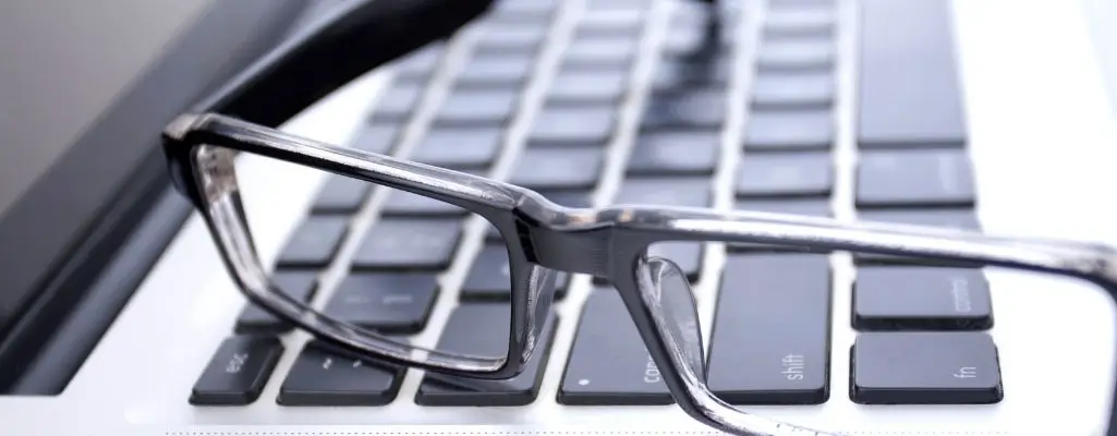 Zdjęcie w artykule - przerwy w pracy. Obraz to zbliżenie na parę okularów położonych na klawiaturze komputera. Scena sugeruje przerwę w pracy lub zakończenie dnia pracy i chwilę odpoczynku.