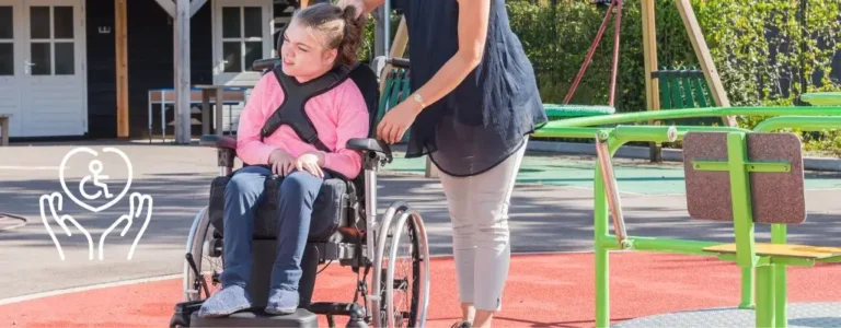 Obrazek wyróżniający do artykułu - orzeczenie o niepełnosprawności dziecka. Na obrazku widoczna jest młoda kobieta prowadząca dziewczynkę na wózku inwalidzkim na placu zabaw. Dziewczynka, ubrana w różowy bezrękawnik i czarną bluzę, wygląda na zadowoloną, uśmiechając się szeroko. Kobieta, w ciemnoniebieskiej bluzce i jasnych spodniach, delikatnie prowadzi wózek, co świadczy o jej trosce i uwadze. Otoczenie jest jasne i kolorowe, z elementami placu zabaw w tle, co dodaje scenie przyjaznego, wspierającego charakteru. Obrazek ten podkreśla znaczenie dostępności i integracji w przestrzeniach publicznych dla osób z niepełnosprawnościami.