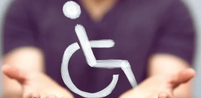 Otwarte dłonie trzymają symbol osoby na wózku inwalidzkim – wyraz troski, wsparcia i akceptacji. Obraz nawiązuje do zmian – od 11 czerwca 2025 r. orzeczenie o niepełnosprawności na 7 lat – i podkreśla ludzką stronę przepisów oraz potrzebę empatii w kontaktach z osobami z niepełnosprawnością.