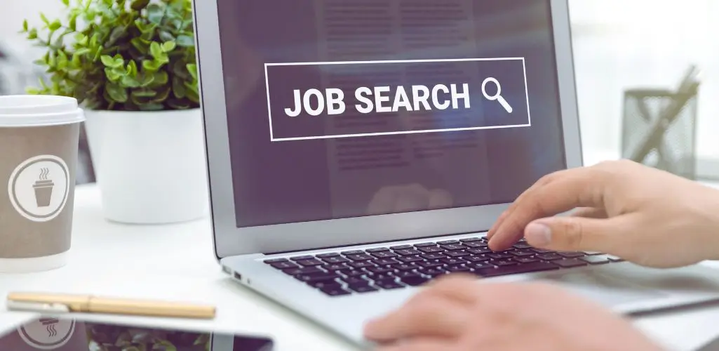 Na których portalach szukać pracy w Polsce w 2025 roku? 3 Na jakich portalach szukać pracy – osoba korzystająca z laptopa z widocznym komunikatem Job Search na ekranie