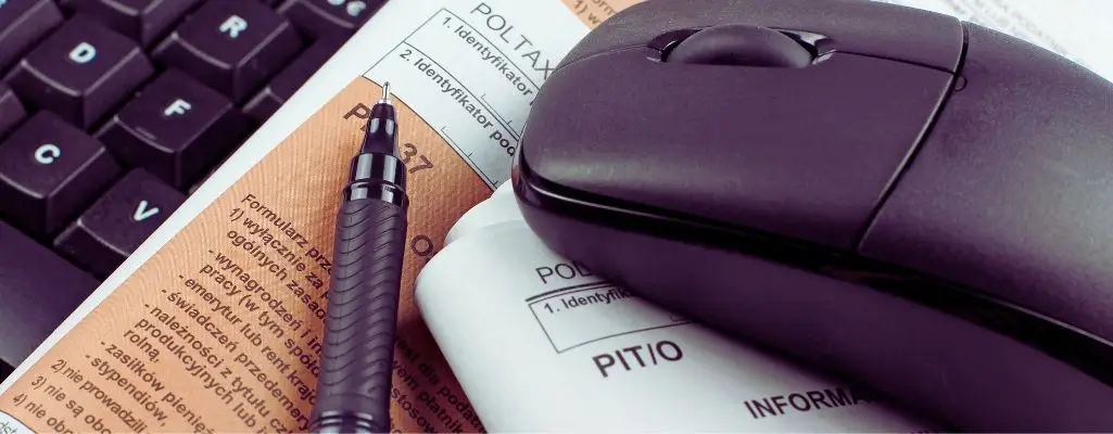 Komu przysługuje ulga rehabilitacyjna w 2026 r.? 1 Komu przysługuje ulga rehabilitacyjna – dokumenty PIT, długopis i mysz komputerowa symbolizujące rozliczenie podatkowe